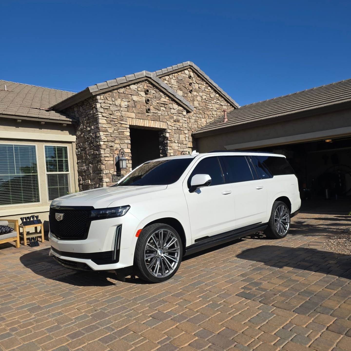 White Cadillac Escalade with dark window tint on a driveway